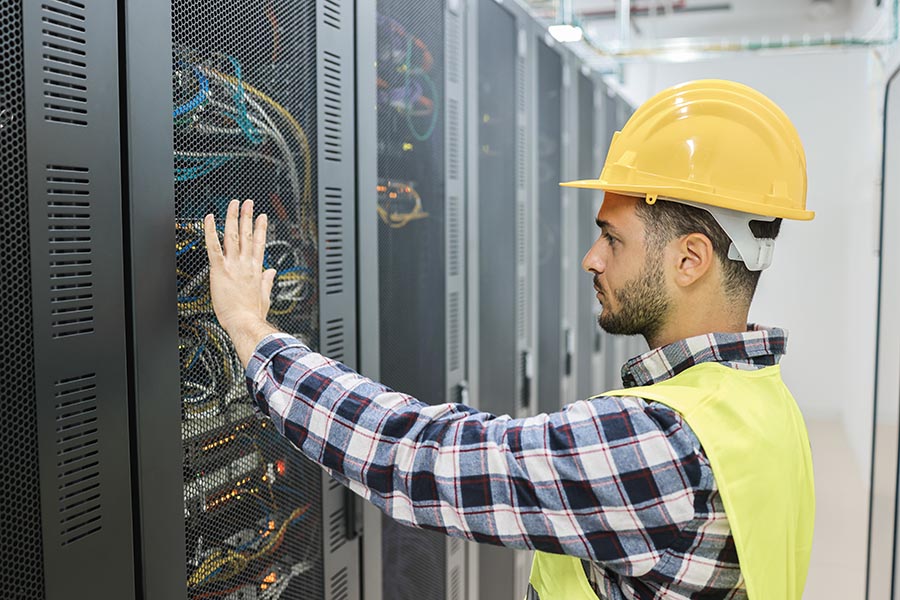 Young technician man working with tablet inside big data center room - Focus on man face